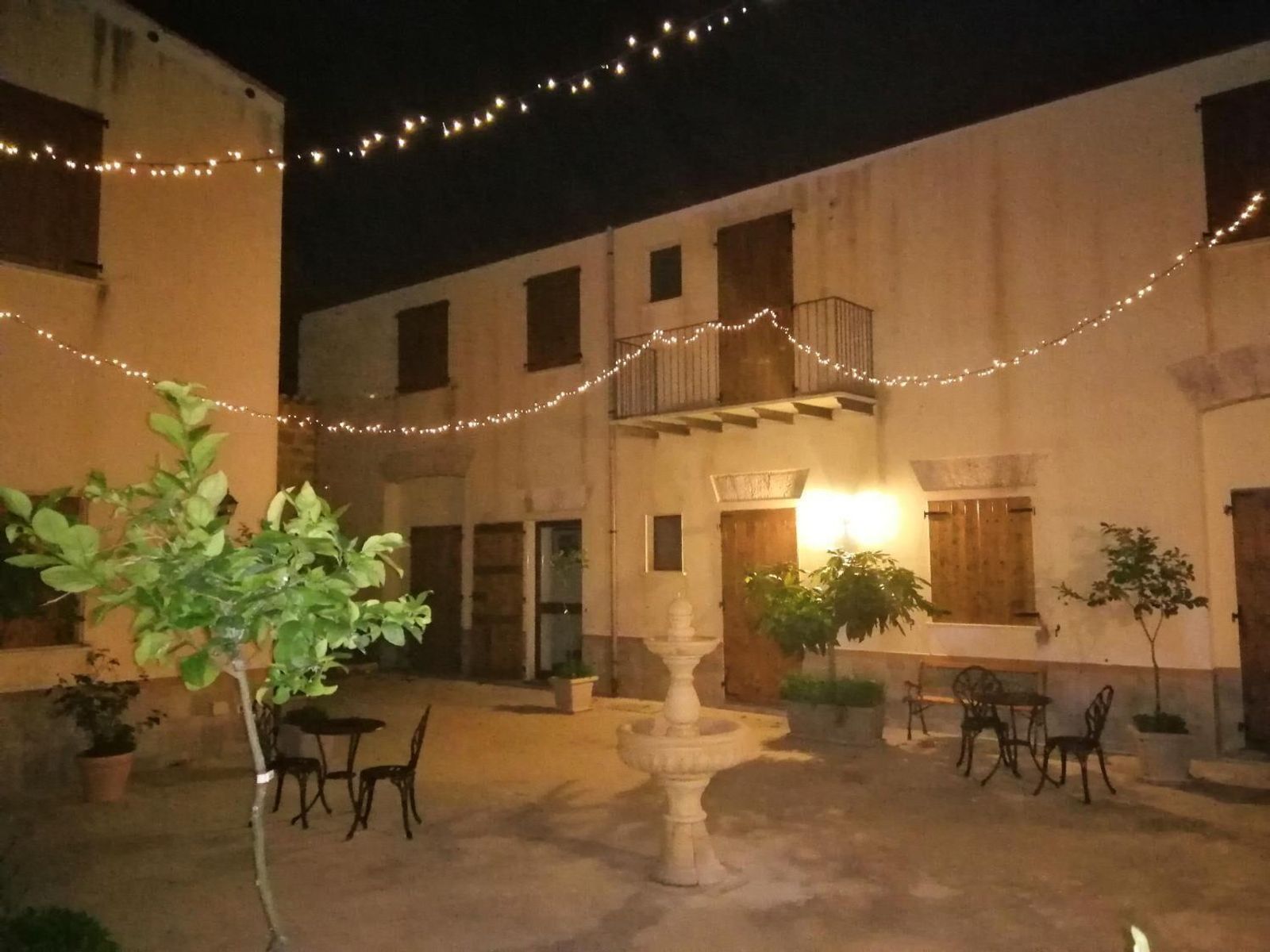 Il cortile illuminato di sera, con le luci sospese